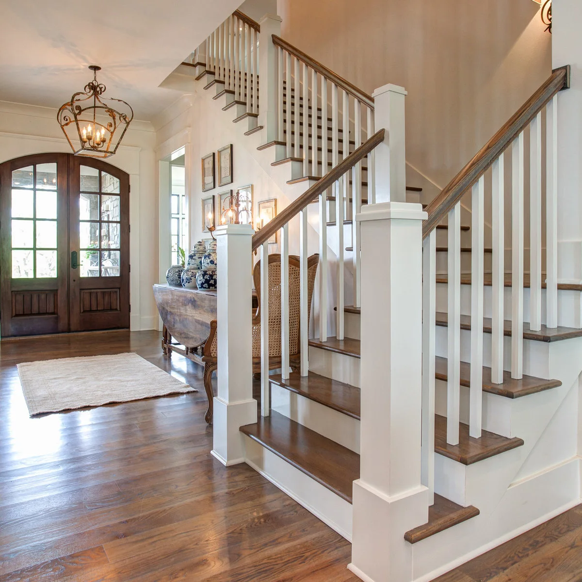 Traditional staircase with white square spindles and risers beside a warm wood handrail and treads