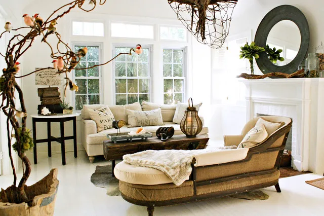 Pale curved seating sits beneath light walls beside warm framed furniture and a dark round mirror.